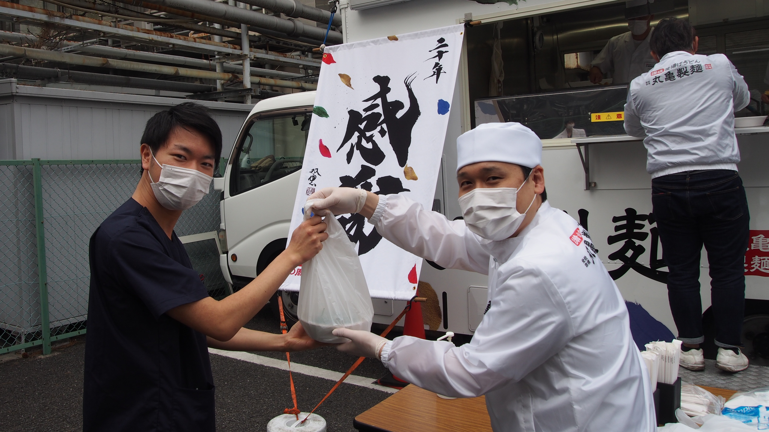 温かいおもてなしに感謝する当院職員（左）と丸亀製麺（右）様